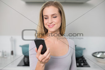 Cheerful gorgeous model holding smartphone