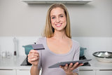 Cheerful gorgeous model holding tablet and credit card
