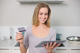 Happy gorgeous model holding tablet and credit card