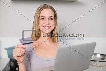 Smiling gorgeous model holding laptop and credit card
