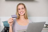 Happy gorgeous model holding laptop and credit card