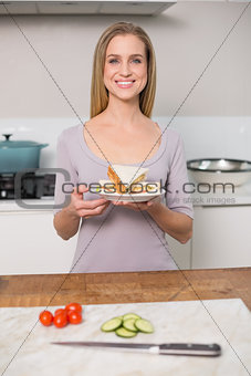 Smiling gorgeous model holding plate with sandwich