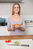 Smiling gorgeous model holding plate with croissant