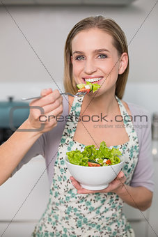Smiling gorgeous model eating salad