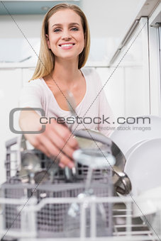 Lucky gorgeous model kneeling behind dish washer