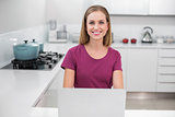 Cheerful casual woman using laptop