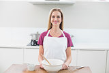 Casual smiling model standing behind baking utensils