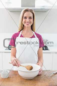 Casual cheerful blonde holding wooden spoon