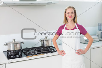 Casual smiling blonde standing next to stove
