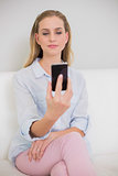 Content casual blonde looking at smartphone