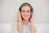 Smiling casual blonde listening to music
