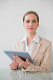Frowning stylish businesswoman using tablet