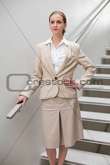Serious stylish businesswoman standing with hand on hip