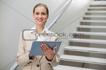 Cheerful stylish businesswoman holding tablet