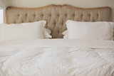 Empty bed with white duvet cover