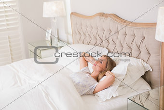 Natural calm woman relaxing in bed