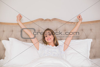 Natural happy woman yawning and resting in bed