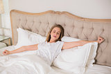 Natural frowning woman yawning and resting in bed