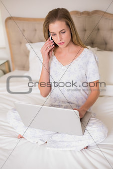 Natural calm woman using laptop and phoning