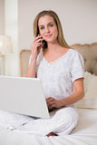 Natural happy woman using laptop and phoning