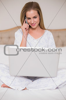 Natural content woman using laptop and phoning