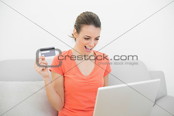 Happy calm woman home shopping with her laptop