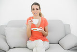 Content brunette woman holding a cup smiling at camera
