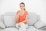Brunette happy woman holding a glass of water smiling at camera