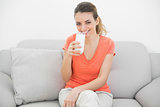 Content peaceful woman holding a glass of milk smiling cheerfully at camera