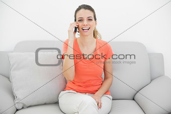 Gorgeous amused woman phoning with her smartphone laughing at camera