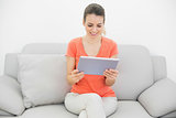 Content peaceful woman using her tablet sitting on couch
