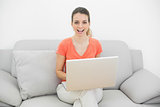Cute casual woman using her notebook sitting on couch
