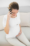 Calm pregnant woman phoning while touching her belly