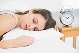 Attractive calm woman lying on her bed under the cover sleeping