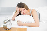 Calm attractive woman lying thoughtful on her bed