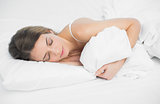 Sweet brunette woman sleeping holding her cover