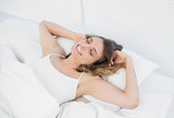 Lovely exhausted woman lying on her bed stretching out