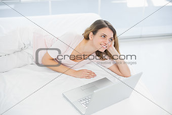 Cheerful woman posing lying on her bed