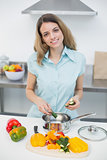 Lovely smiling woman cooking standing in kitchen