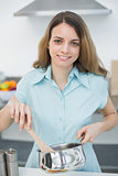 Calm beautiful woman cooking smiling at camera