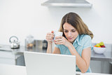 Cute calm woman working with her notebook holding a cup