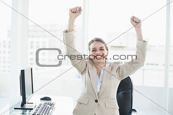Cheering brunette businesswoman sitting in her office