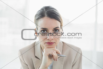 Young gorgeous businesswoman wearing glasses looking at camera
