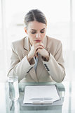 Focused young businesswoman sitting at her desk reading her notes