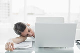 Pretty exhausted businesswoman sitting at her desk sleeping