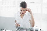 Attractive focused businesswoman working sitting at her desk