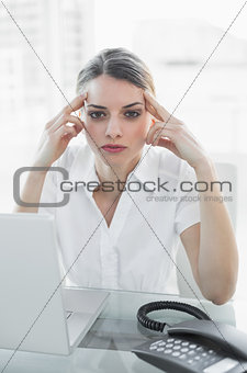 Businesswoman having a headache at work