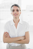 Attractive businesswoman posing with arms crossed looking at camera