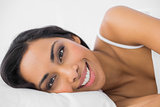 Gorgeous calm woman lying under the cover on her bed
