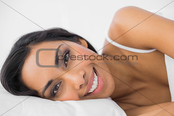 Gorgeous calm woman lying under the cover on her bed